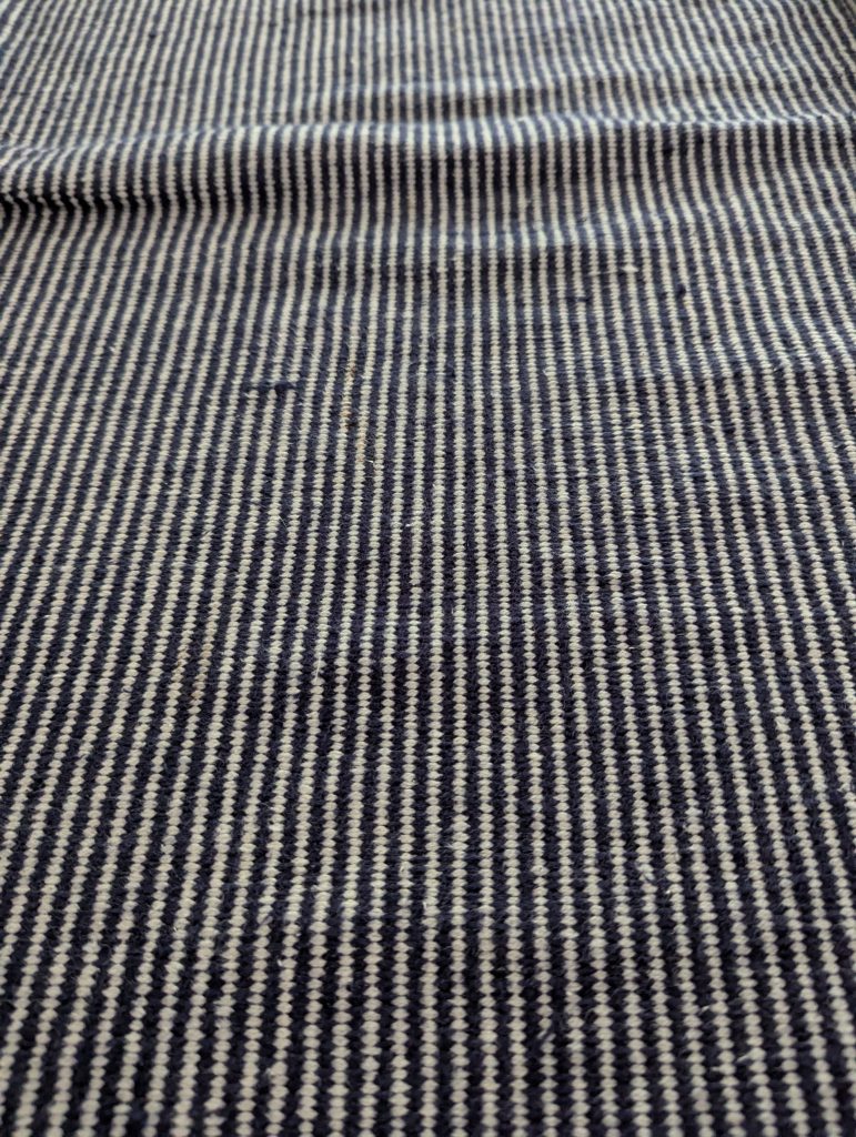Woven rug on tile surface – showcasing layered cleaning challenges for mixed flooring