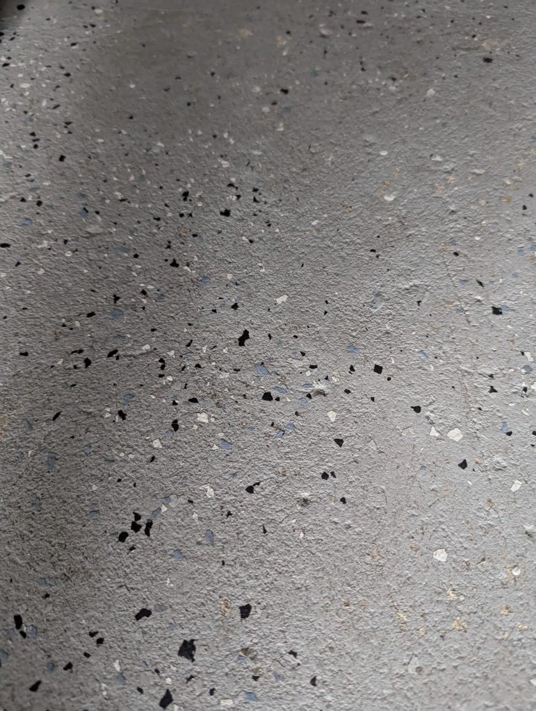 Outdoor matte gray terrazzo with embedded chips – before using terrazzo floor polish and cleaner